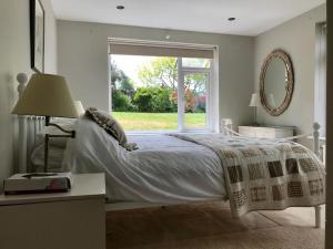 a bedroom with a bed and a large window at Phoenix Cottage in Kippford