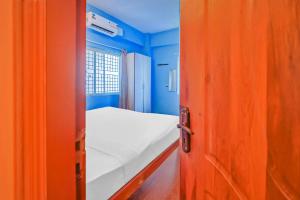 eine offene Tür zu einem kleinen Zimmer mit einem Bett in der Unterkunft Hotel O Sri Sai Guru Comforts in Bangalore + 32 Fotos