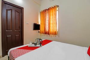 a bedroom with a bed and a window at Super OYO Mn Residency Near Ragigudda Sri Prasanna Anjaneyaswamy Temple in Bangalore