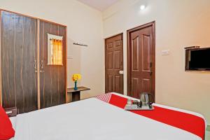 a bedroom with a large bed and a television at Super OYO Mn Residency Near Ragigudda Sri Prasanna Anjaneyaswamy Temple in Bangalore