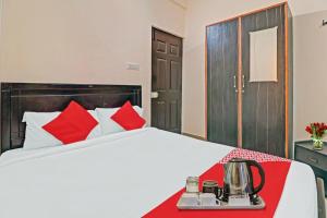 a hotel room with a bed with red pillows at Super OYO Mn Residency Near Ragigudda Sri Prasanna Anjaneyaswamy Temple in Bangalore