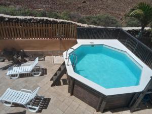 a large swimming pool with two lounge chairs at Casa Livia Pool & Sunset in Corralejo