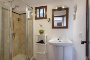 a bathroom with a shower and a sink and a mirror at Casa Los Divisos in Teguise