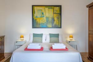 a bedroom with a white bed with two lamps at Casa Los Divisos in Teguise