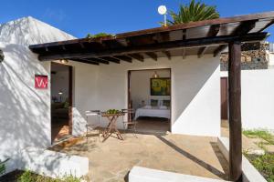 un patio con una mesa y un edificio blanco en Casa Los Divisos, en Teguise