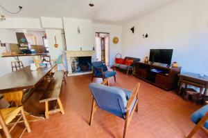 een woonkamer met een tafel en stoelen en een televisie bij La Maison des Sauges - Village house with garden 500m from the beach in Le Grau-du-Roi