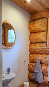 a bathroom with a sink and a log wall at Rahu ja vaikus in Kivilõppe