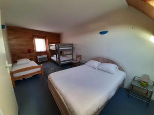 - une petite chambre avec un lit et une chaise dans l'établissement Le Petit Michelet, à Granville