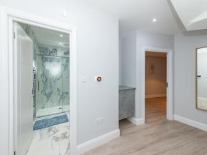La salle de bains est pourvue d'une douche en verre dans un mur blanc. dans l'établissement Pass the Keys Brand New Stylish 2BR Flat in Reading Centre, à Reading