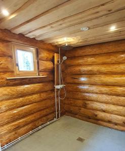 a room with a wooden wall with a shower in it at Rahu ja vaikus in Kivilõppe
