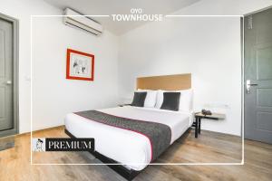 a bedroom with a large white bed in a room at Super Townhouse Boutique Hotel 242 Sarjapur Road in Bangalore