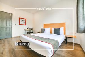 a hotel room with a large bed and a door at Super Townhouse Boutique Hotel 242 Sarjapur Road in Bangalore
