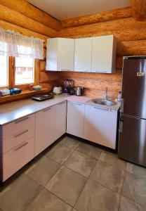 a kitchen with white cabinets and a stainless steel refrigerator at Rahu ja vaikus in Kivilõppe
