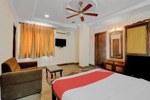 a bedroom with a bed and a ceiling fan at OYO Royal Grand Residency Near Lalbagh Botanical Garden in Bangalore