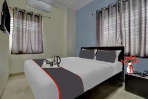a bedroom with a large white bed and curtains at Flagship Hotel Sai Orchid in Bangalore