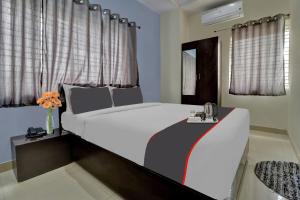 a bedroom with a large white bed with curtains at Flagship Hotel Sai Orchid in Bangalore