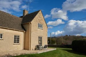 a house with chairs sitting outside of it at Garden House in Cirencester