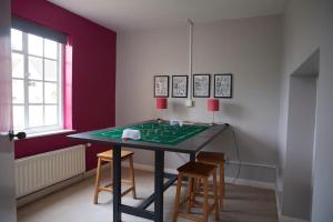 a ping pong table in a room with two chairs at Garden House in Cirencester