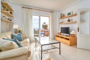 ein Wohnzimmer mit einem Sofa und einem TV in der Unterkunft Balcon Bella Vista in Nerja