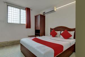 een slaapkamer met een groot bed met rode kussens bij OYO K N Residency in Yelahanka