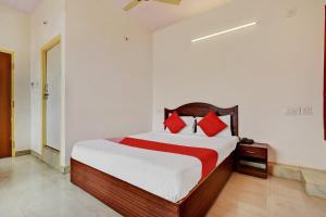 een slaapkamer met een groot bed met rode kussens bij OYO K N Residency in Yelahanka