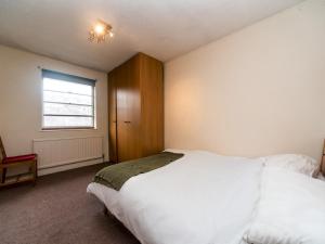 a bedroom with a large white bed and a window at Pass the Keys - Cosy Maisonette with Garden in Central East London in London