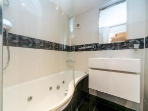a white bathroom with a tub and a sink at Pass the Keys - Cosy Maisonette with Garden in Central East London in London