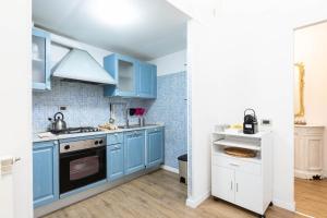 cocina con armarios azules y fogones en Toniolo Two Bedroom Two Bath, en Roma
