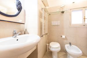 Un baño blanco con lavabo e inodoro. en Toniolo Two Bedroom Two Bath, en Roma