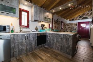 a kitchen with wooden cabinets and wooden floors at Orianna Apartment Airport by Airstay in Spáta