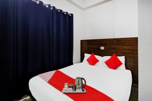 um quarto com uma cama com almofadas vermelhas em Flagship Pride Inn em Bangalore