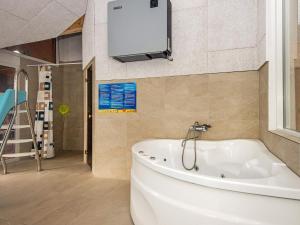 La salle de bains est pourvue d'une baignoire et d'une télévision murale. dans l'établissement 8 person holiday home in Ebeltoft, à Ebeltoft