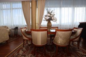 a dining room with a table with chairs and a vase of flowers at Apart-hotel Integra in Banja Luka