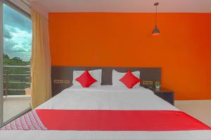 a bedroom with a bed with red and white pillows at OYO Flagship Blooms Residency Near Baiyappanahalli Metro Station in Bangalore