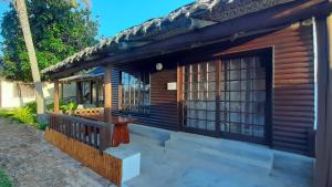 a wooden house with a porch and a balcony at Venha Juntos Guest Homes in Miramar