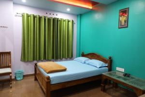 a bedroom with a bed and a green curtain at Ammukutty's Cottage in Munnar