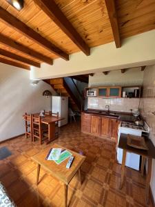 cocina grande con suelo de madera y mesa en Alamos del Arroyo en San Martín de los Andes