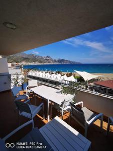 um restaurante com mesas e cadeiras e a praia em Suite home em Giardini Naxos