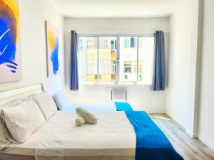 Un dormitorio con una gran cama blanca con toques azules en Copacabana Suite at the Beach, en Río de Janeiro