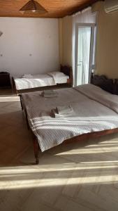 1 Schlafzimmer mit 2 Betten und einem Fenster in der Unterkunft Angela - Zoi Rooms in Skiathos-Stadt