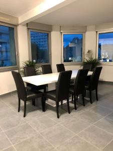 una mesa y sillas en una habitación con ventanas en Appartement de 110m2 au centre de Cusset, en Cusset