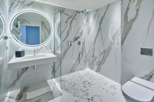 uma casa de banho com um chuveiro, um lavatório e um espelho. em La Licorne Hotel & Spa Troyes MGallery em Troyes