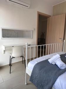 1 dormitorio con cama, escritorio y silla en Seana House in a luxury resort in Protaras area close to the Sea, en Paralimni