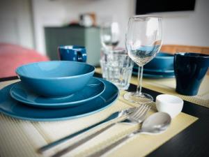 a table with blue plates and a glass of wine at Flamingo Studio's Zeeland in Schoondijke