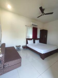 una camera con un letto e un divano di Aloha Farm & Camp a Udaipur