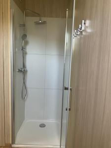 La salle de bains est pourvue d'une douche avec une porte en verre. dans l'établissement Petite Maison Contemporaine, à Saubion