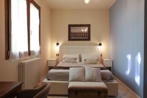 a bedroom with a large white bed with a chair at La Corte del Pratello in Bologna