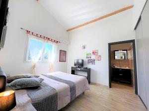 sypialnia z łóżkiem i telewizorem w obiekcie La villa Thomas avec piscine chauffée, classée 4 étoiles w mieście Serra-di-Ferro