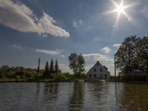 una casa sentada junto a un gran cuerpo de agua en Pension Buschmühle, en Ohorn