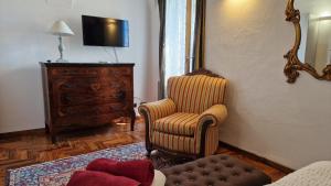 un soggiorno con sedia e TV di Maison Paradiso: Charme e relax a Pietra Ligure a Pietra Ligure